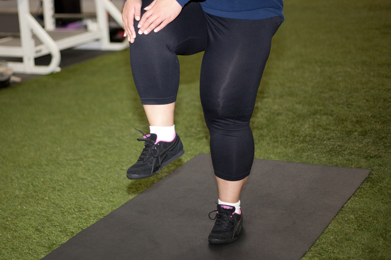 Un estiramiento de rodillas en posición de pie también fortalece su núcleo y le ayuda a aprender el equilibrio adecuado.Las flexiones de rodillas similares repetidas en la habitación de forma ambulante se convertirían en una variación de una marcha de rodilla alta, un ejemplo de estiramiento dinámico.