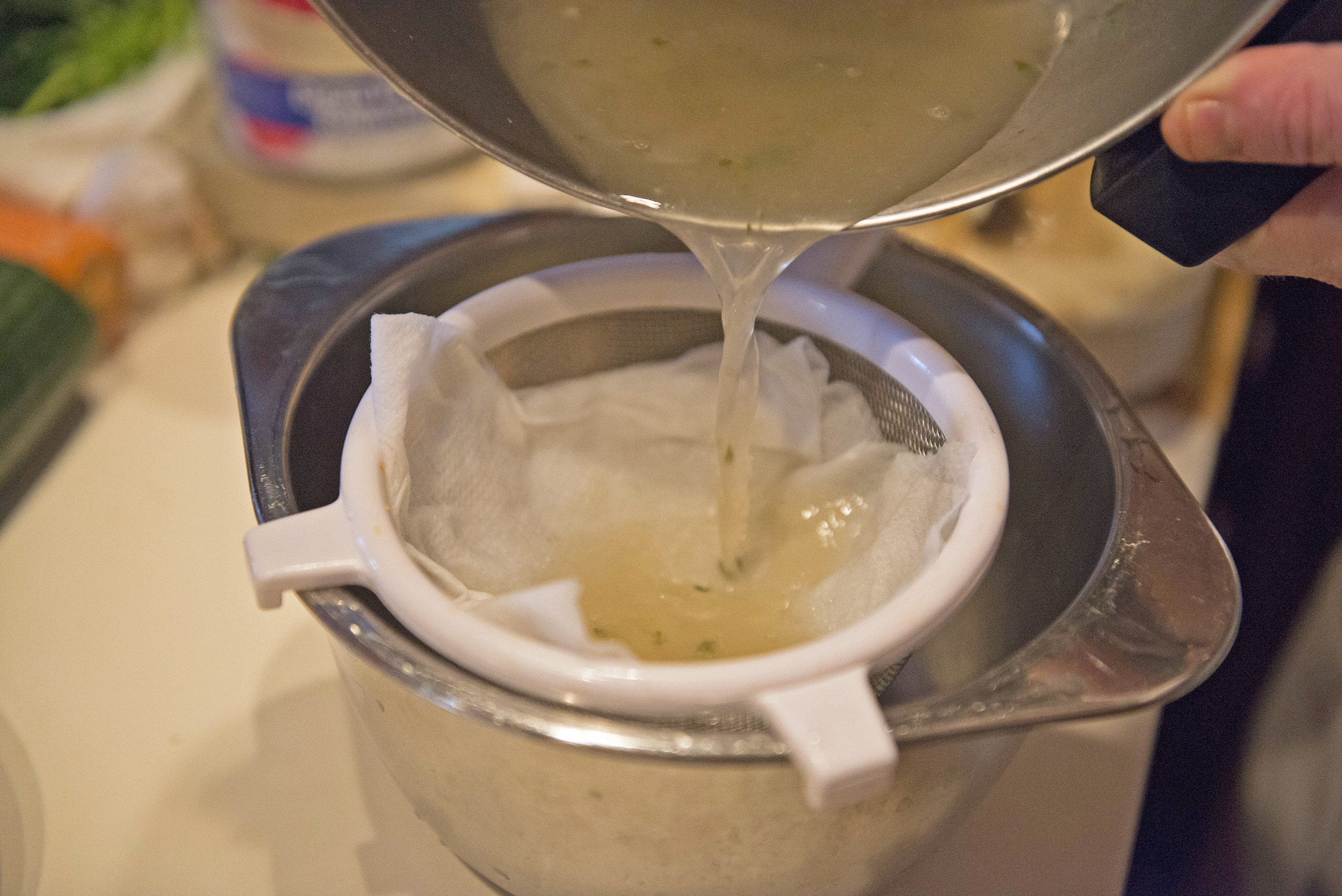 Straining broth with a colander